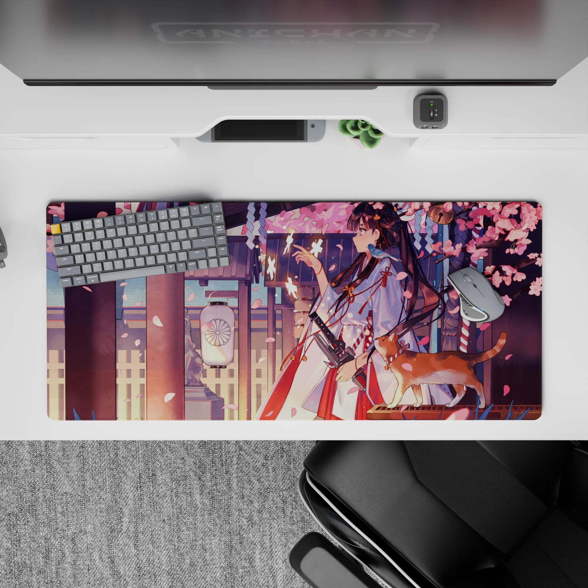 36x16 inches anime desk pad in pink, plum, and warm gold tones with soft lantern mood and petals.