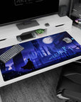 Silhouetted anime hero in sweeping cloak on desk pad 40x20 inches, watching a moonlit city.