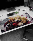 Golden-haired anime girl in red-black armor straps on desk pad 40x20 inches, magenta ribbons swirling.