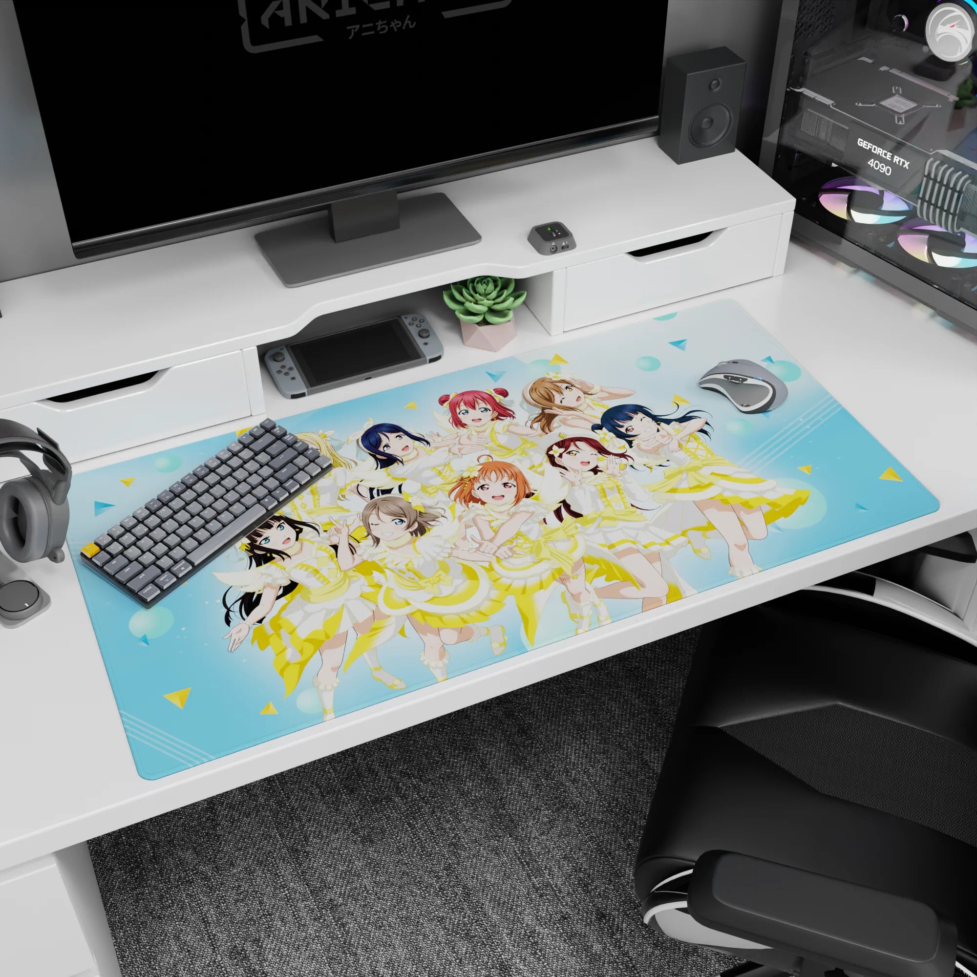 Nine anime idols mid-encore on a 40x20 inches desk pad, winks, peace signs, and flower clips.