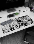 Anime desk pad 36x16 inches showing a calm bald fighter and a caped brawler charging through chaos.