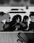 40x20 inches Naruto desk pad in grayscale with vivid red Sharingan and purple Rinnegan, dark Akatsuki vibe.