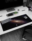 Dreamy space scene desk pad 36x16 inches showing a swirling galaxy with dusted stars and soft glow.