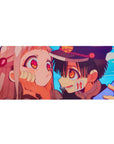 36x16 inches anime desk pad with boy in school cap cupping pink-haired girl's cheeks on sky-blue background.