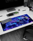 Golden-haired anime heroine lounging with smirk, swirling skirt and floating green charm desk pad 36x16 inches.