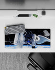 Moody black space anime girl mouse pad 28x12 inches with icy planet glow and blue paint-splash accents.