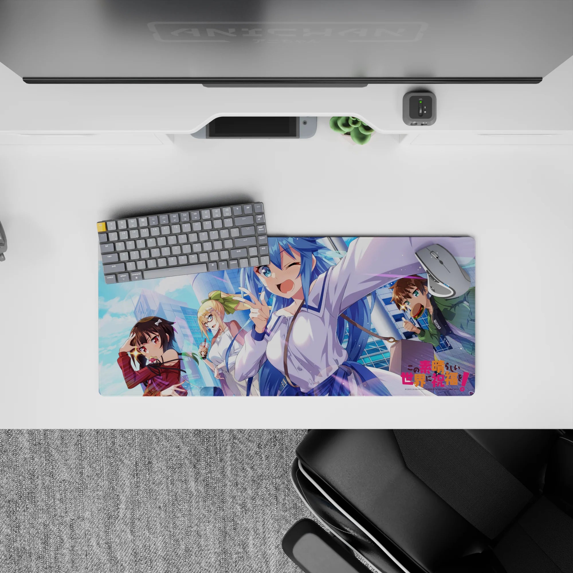 KonoSuba anime mouse pad 28x12 inches featuring Aqua, Megumin, Darkness, and Kazuma with vibrant city backdrop.