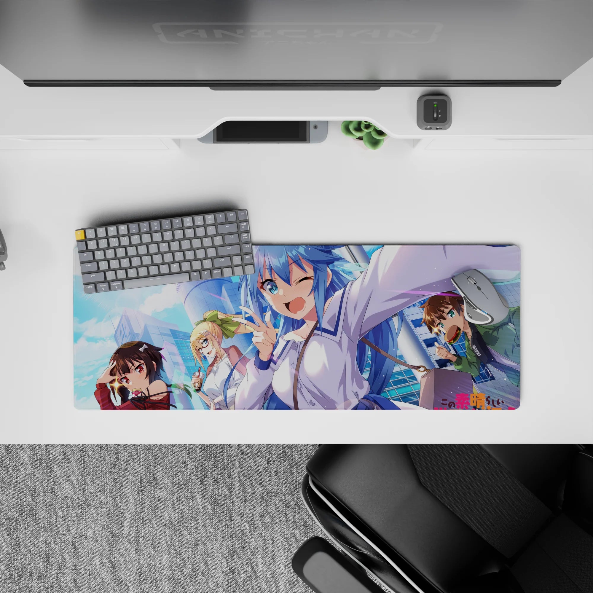 KonoSuba anime mouse pad 32x12 inches featuring Aqua, Megumin, Darkness, and Kazuma against a vibrant cityscape.