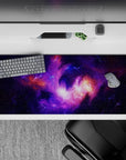 Deep violet and lilac desk pad 36x16 inches with warm orange nebula glow, calm late-night vibe.