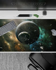 Calm cosmic desk pad 40x20 inches in smoky black, stardust gold, and cool teal for a night-sky vibe.