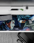 36x16 inches anime desk pad in icy blues and smoky grays with glowing red Sharingan sparks.