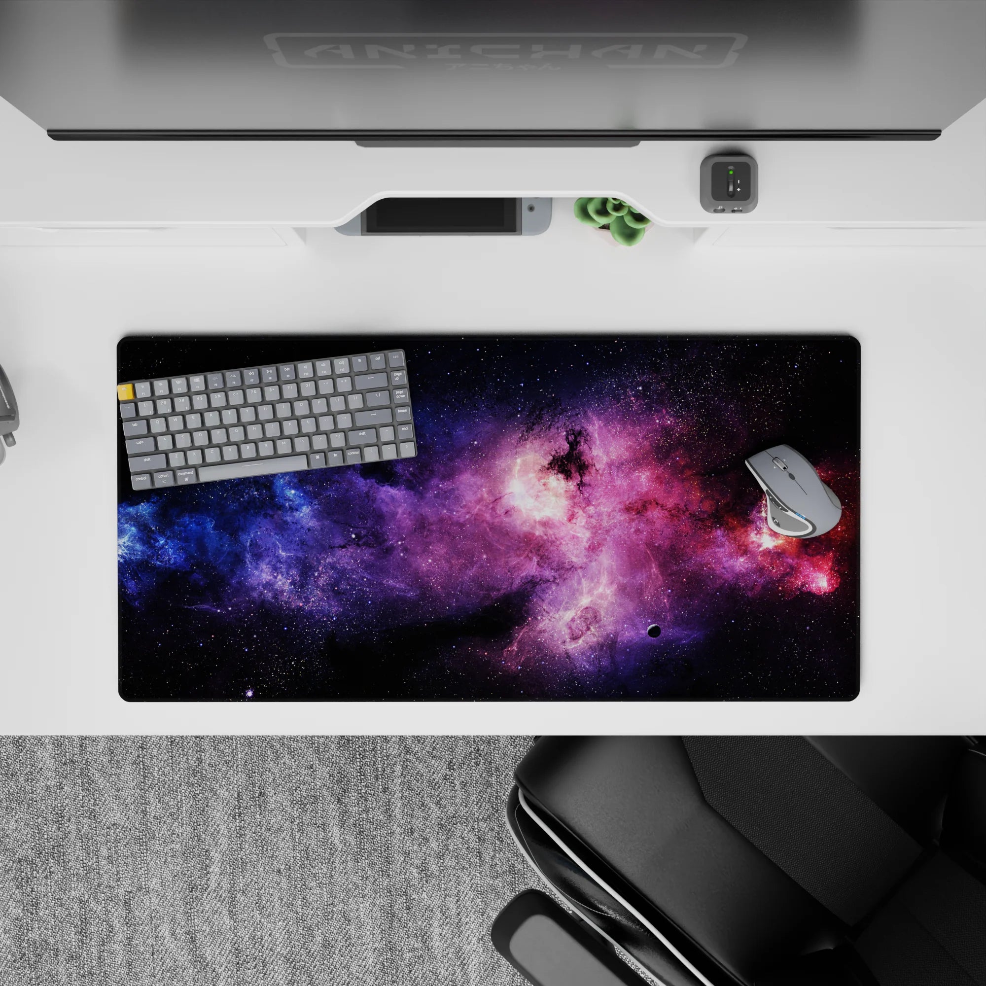 Moody space mouse pad 32x16 inches in dark backdrop with violet haze, electric blue and magenta glow.