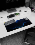 Neon-blue edge circling swirling night clouds and tiny stars on desk mouse pad, 28x12 inches.