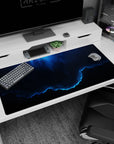 Midnight storm sky scene desk pad 40x20 inches showing swirling clouds, star specks, and neon-blue rim light.