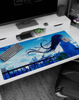 Long-haired anime girl watching the skyline at sunset desk pad 40x20 inches with breezy petal specks.