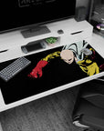 Saitama rockets forward, cape snapping, fist centered on anime desk pad 40x20 inches.