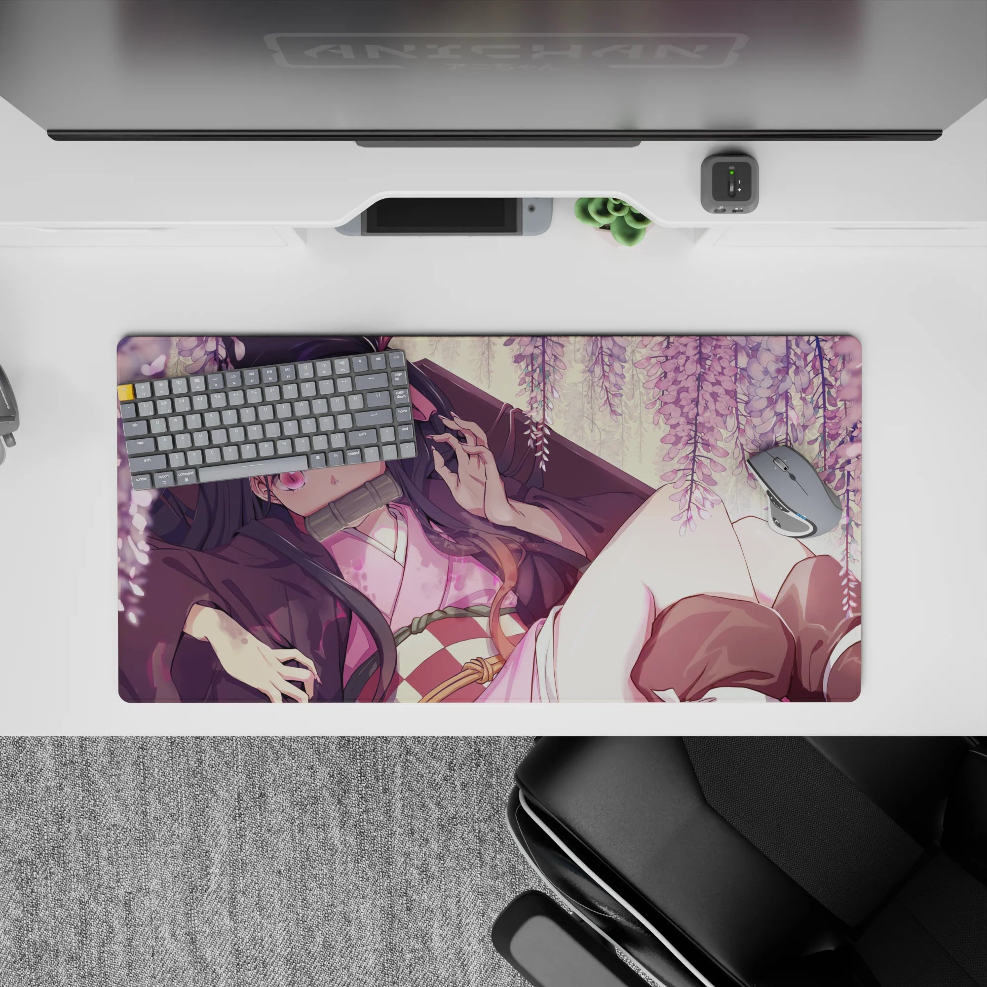 Nezuko from Demon Slayer lounges under wisteria on a 32x16 inch anime mouse pad, surrounded by blush-pink blooms.