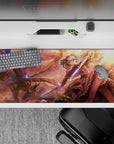 Cinematic 36x16 inches anime desk pad in copper, rose, and gold clouds with glowing blue magic confetti.