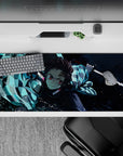 Tanjiro from Demon Slayer in action on a 36x16 inch anime desk pad, featuring dynamic water-breathing style and vivid colors.