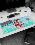 36x16 inches Love Live desk pad featuring Umi Sonoda and Dia Kurosawa in red-trim idol outfits.