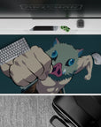 Anime desk pad 40x20 inches featuring Inosuke from Demon Slayer mid-punch with teal backdrop highlighting his energy.