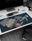 Inosuke from Demon Slayer mid-punch on anime desk pad, 40x20 inches, with teal backdrop accentuating his fierce energy.