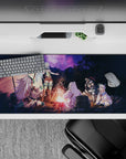 36x16 inches anime desk pad in warm orange firelight with deep violet night sky and starry glow.