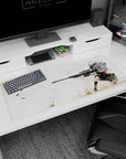 Anime girl desk pad 36x16 inches showing a calm sharpshooter, hair whipping, braced behind a sniper rifle.