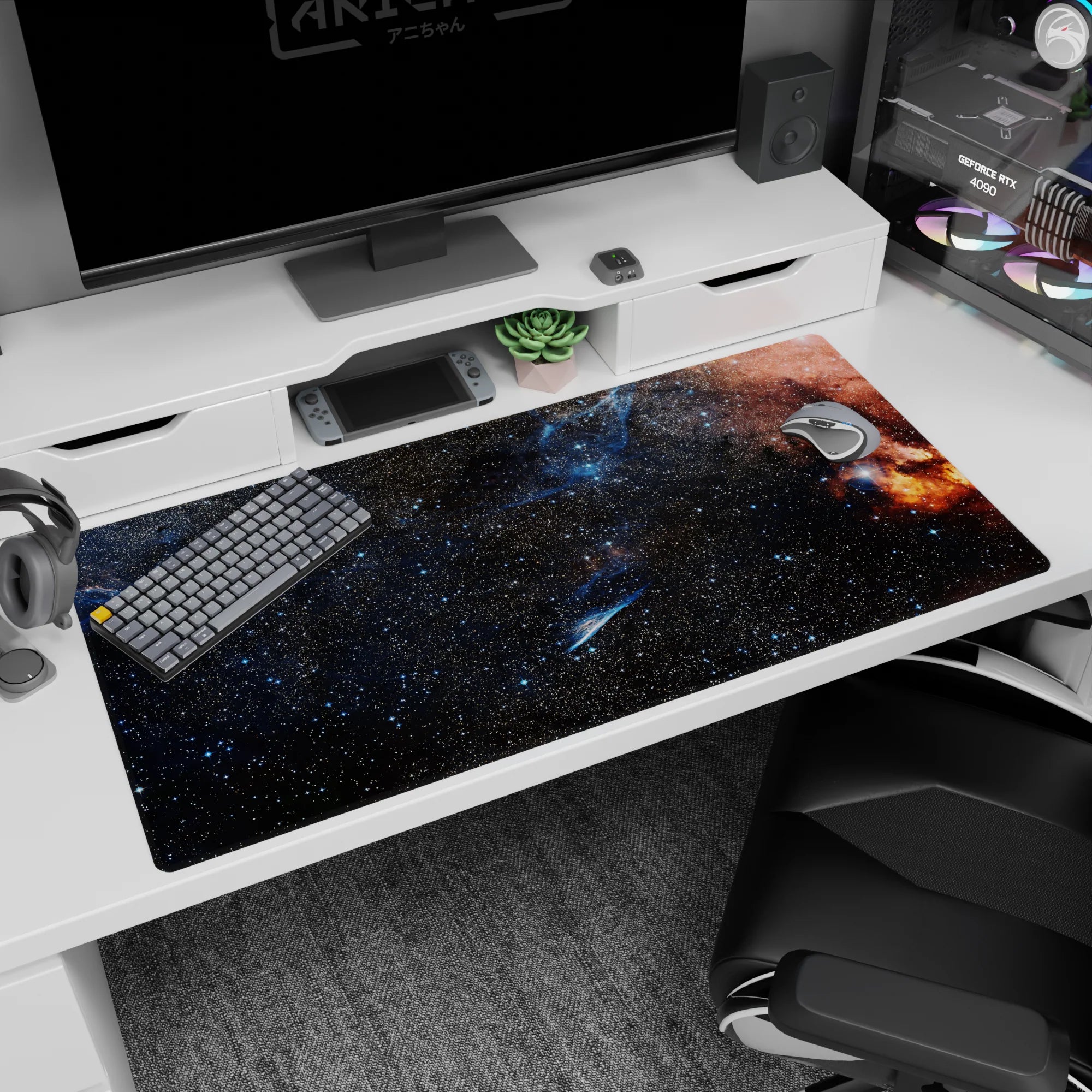 Desk pad 40x20 inches showing a starry midnight galaxy with an orange nebula bloom at the edge.