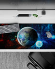 Cosmic desk pad in nebula blues, inky blacks, and fiery red accents, 36x16 inches.
