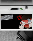 Black background anime mouse pad with peach tones, white eyes, and red anger mark, 32x16 inches.