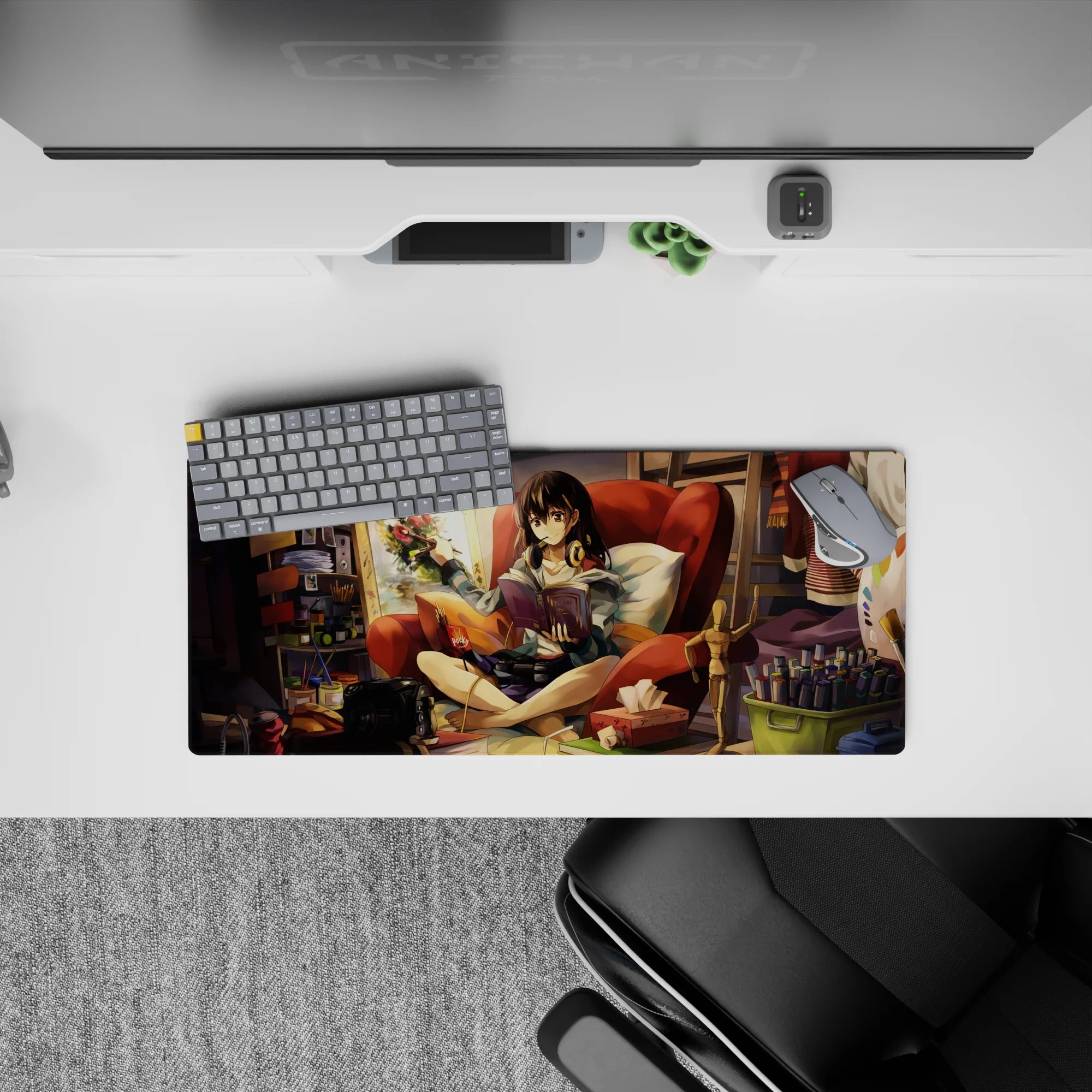 28x12 inches anime girl mouse pad in warm oranges and deep reds, cozy lamp-lit creative clutter vibe.