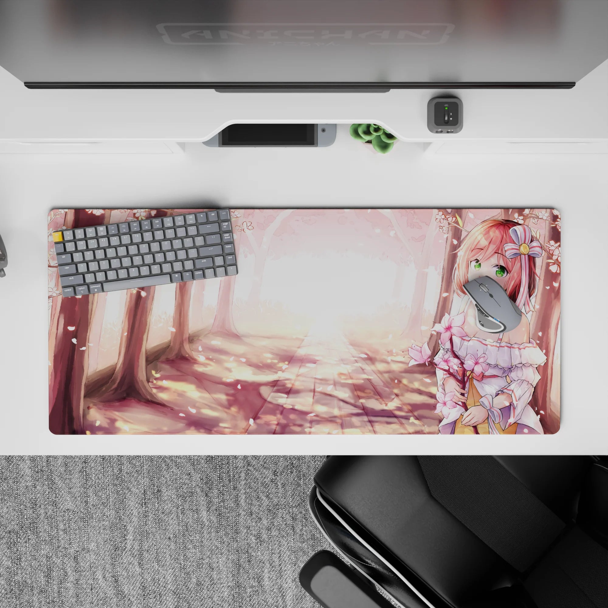 36x16 inches anime desk pad in blush pink sakura tones with warm golden glow and soft forest shadows.